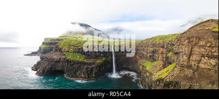 Elevata vista panoramica della cascata e scogliere, Gasadalur, funzionario ministeriale isola, isole Faerøer, Danimarca Foto Stock