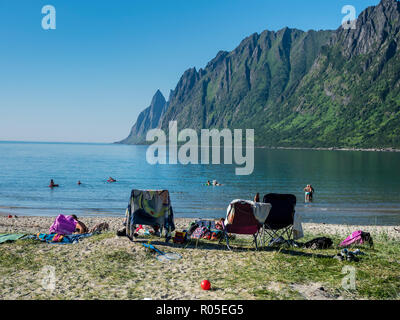 Spiaggia Ersfjordstranden, fjord Ersfjord, pubblica Recreation Area, estate, tempo per fare una nuotata, sedie, vista la gamma della montagna Okshornan, isola Senja, Troms, Foto Stock