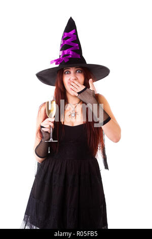 Foto di ridere strega in black hat, con un bicchiere di champagne su sfondo bianco Foto Stock