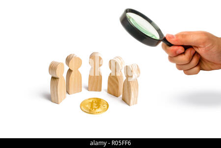 Statuine di legno di persone sono in piedi intorno ad una moneta bitcoin su uno sfondo bianco. cryptocurrency blockchain e tecnologia. Il decentramento del Foto Stock