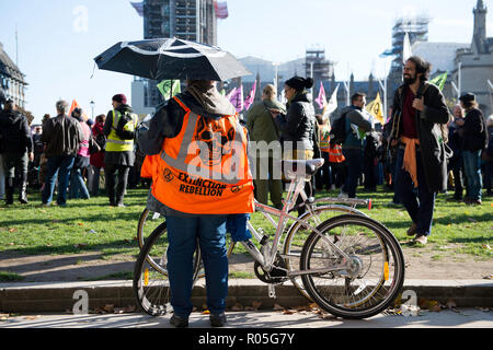 Attivista ambientale visto indossare una ribellione di estinzione gilet durante la protesta. La neonata estinzione gruppo di ribellione, preoccupati per il cambiamento climatico, le chiamate per una massa pacifica di disobbedienza civile per evidenziare i politici con la mancanza di impegno e di azione per quanto riguarda le questioni ambientali. Gli attivisti si sono riuniti presso la piazza del Parlamento e bloccato la strada per due ore. La protesta degli altoparlanti inclusi come Greta Thunberg, Caroline Lucas e George Monbiot. Secondo la ribellione di estinzione 15 persone sono state arrestate nella protesta. Foto Stock