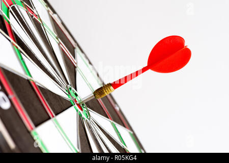 Immagine ravvicinata di colore verde e rosso freccette frecce nel centro di destinazione. Business bersaglio o obiettivo di successo e vincitore del concetto. Foto Stock