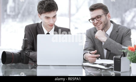 Fotografi qualificati discutere le foto per caricare i file su un computer portatile . Foto Stock