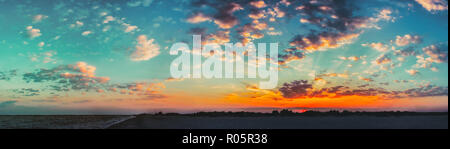 Sole che splende su orizzonte durante il tramonto Sunrise. Panorama del Mare Costa dell'oceano. Cielo naturali dai colori caldi. Vista panoramica, Panorama Foto Stock