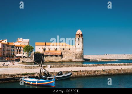 Collioure, Francia. Barche ormeggiate sulla banchina di ormeggio nei pressi della chiesa di Nostra Signora degli Angeli su Bay nella soleggiata giornata di primavera. Foto Stock