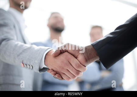 Due imprenditori in giacca agitando mani alla riunione di gruppo, partner di handshaking negoziati a rendere trattare o firma un contratto Foto Stock