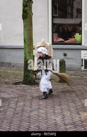 Deventer, Paesi Bassi, dicembre 21, 2014: bambina in costume vittoriano dress spazza la strada con una scopa durante il festival Dickens in de Foto Stock