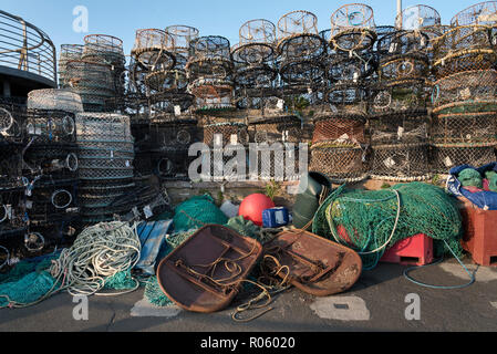 Le reti da pesca, aragoste, pentole e altri attrezzi da pesca sulla banchina del porto di Brixham, Devon, Regno Unito Foto Stock