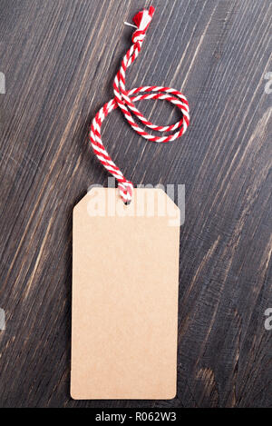 Carta riciclata tag con un punto rosso e bianco sulla corda a nero lo sfondo della scheda Foto Stock