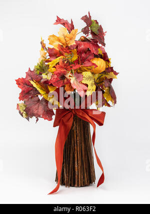 Bouquet di fake Foglie di autunno e bastoni legato con un fiocco rosso, isolato su sfondo bianco. Foto Stock