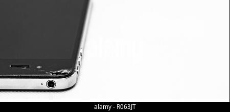 Generic rotto nero smartphone con una crepa, isolato su sfondo bianco. Foto Stock