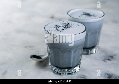 Trend alimentari - latte macchiato di carbone su sfondo marmo, spazio di copia Foto Stock