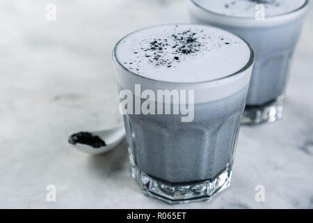 Trend alimentari - latte macchiato di carbone su sfondo marmo, spazio di copia Foto Stock