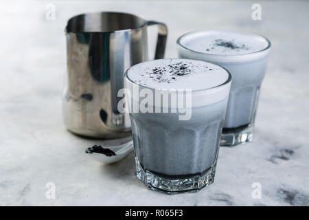 Trend alimentari - latte macchiato di carbone su sfondo marmo, spazio di copia Foto Stock