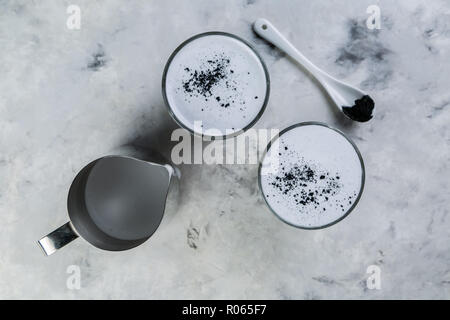 Trend alimentari - latte macchiato di carbone su sfondo marmo, spazio di copia Foto Stock