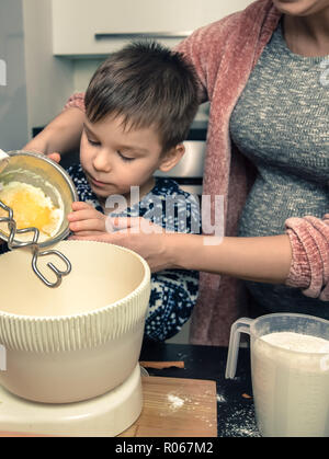 Felice famiglia amorevole in cucina. La madre e il bambino preparare la pasta, cuocere i biscotti in forno Foto Stock