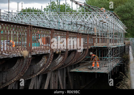 Un dipendente AMCO ispeziona decadendo lamiera su una ferrovia in disuso viadotto sopra la B6049 e il fiume Wye in Millers Dale. Foto Stock