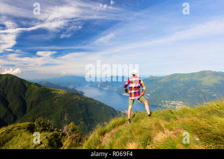 Escursionista sul Monte Legnoncino ammira il lago di Como e provincia di Lecco, Lombardia, Italia, Europa Foto Stock