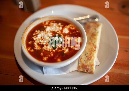 Ciotola di zuppa di pomodoro con formaggio di capra e pane piatto stick. Foto Stock