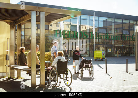 Ottobre 2018. Germania, Helios Klinikum Krefeld. Un gruppo di pensionati in sedie a rotelle poggia su un quadrato in un parco vicino l'entrata dell'ospedale. Foto Stock