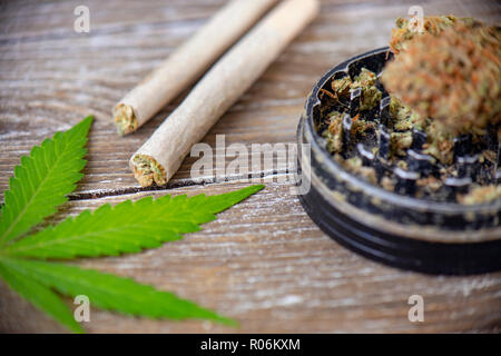La Cannabis giunti con carta di laminazione e macinare su uno sfondo di legno Foto Stock