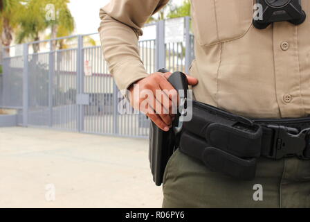 Scuola di concetto di sicurezza - AGENTE DI POLIZIA ARMATO sul dovere di protezione campus chiusa di alta scuola in California Foto Stock