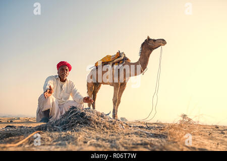 Il Cammello trader rilassante sulla duna di sabbia nel deserto di Thar in Jaisalmer, India. Foto Stock