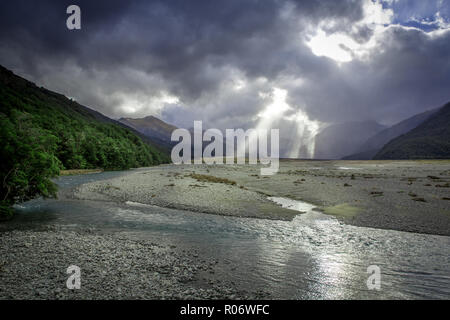 La luce del sole che splende attraverso le nuvole durante un acquazzone getta una drammatica scena sopra la valle di Canterbury, Nuova Zelanda Foto Stock