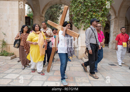 Un gruppo di uomini e donne ai turisti in una bibbia tour a piedi il percorso della Via Crucis nella Città Vecchia di Gerusalemme, Israele Foto Stock