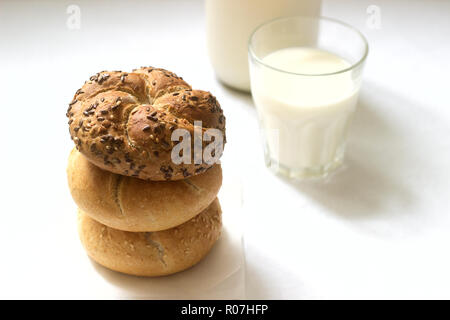 Frumento e segala Kaiser panini con lino e i semi di sesamo servito con latte e sana prima colazione. Foto Stock