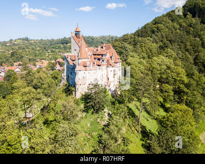 Castello di Bran su una collina con alte guglie e pareti, tetti di tegole rosse, circondato dalla città di crusca, Valacchia, Transilvania, Romania. Conosciuto come castello di Dracula Foto Stock