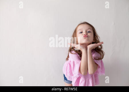 Una piccola ragazza in un abito rosa air Kiss Foto Stock