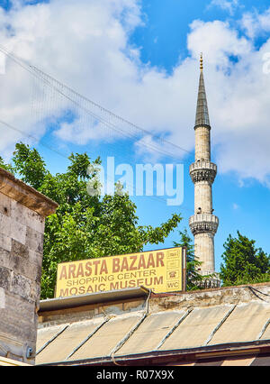 L'Arasta Bazaar cartello con un minareto della Sultan Ahmet Camii moschea in background. Il quartiere di Fatih, Istanbul, Turchia. Foto Stock