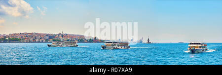 Traghetti attraversando il Bosforo, con il quartiere Eminonu skyline e la fanciulla la torre in background. Istanbul, Turchia. Foto Stock