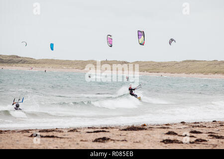 Kite surfisti fuori nei loro numeri su Rhosneiger Beach, Rhosneiger, Galles del Nord, Anglesey, Regno Unito Foto Stock