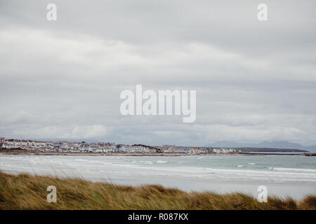 Vista di Rhosneigr da fino nelle dune di sabbia sulla spiaggia Cymyran, Anglesey, Galles del Nord, Regno Unito Foto Stock