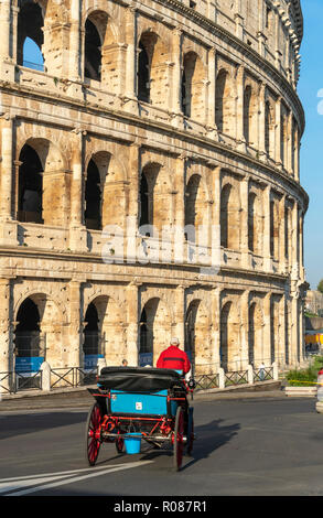 Un cavallo e carrozza passa dal Colosseo nel centro di Roma, Italia. Foto Stock