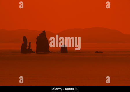 Il Drongs stagliano arancione tramonto, mare pile in St Magnus Bay nei pressi di Ness di Hillswick, Northmavine, isole Shetland, Scotland, Regno Unito Foto Stock