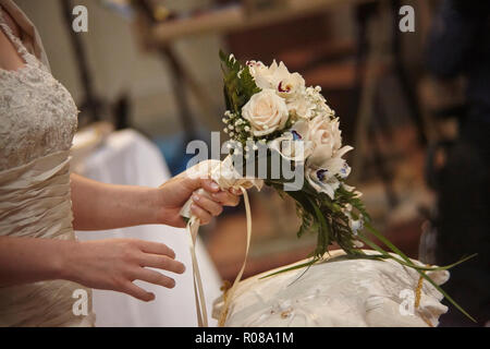 Bouquet doppio tenuto in mano dalla sposa durante la celebrazione del matrimonio. Foto Stock