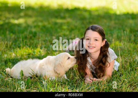 Ragazza e cane posa sull'erba Foto Stock