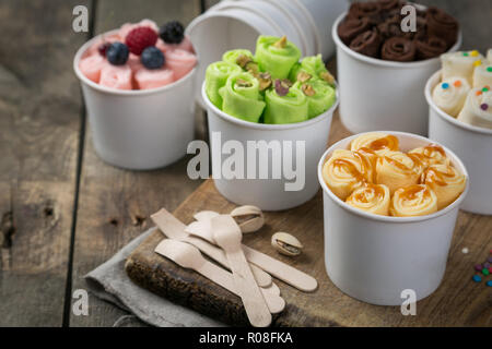 La selezione di diversi laminati di gelati in cono tazze, legno rustico sfondo, spazio di copia Foto Stock