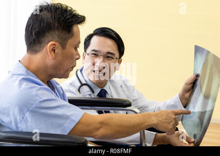 Medico spiegando x-ray risultati al paziente senior e il suo relativo Foto Stock