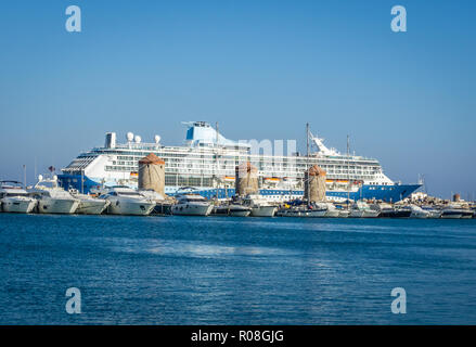 La foto in orizzontale del grande oceano mare cruiser. Barca è in vecchio antico porto di Rodi città capitale. Parecchie navi di piccole dimensioni sono in parte anteriore del vecchio mulino in pietra Foto Stock