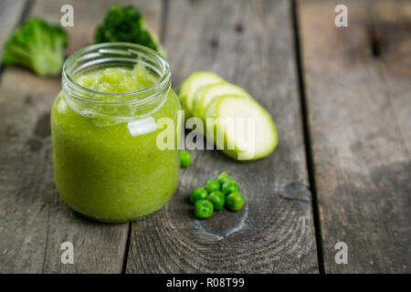 Green baby food purè in vasi di vetro con ingredienti. Una sana organic baby food concept. A partire cibo solido, consegna Foto Stock