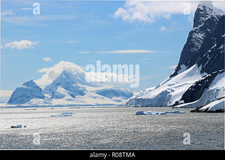 Neve scintillante delle cime circostanti le acque scintillanti della stupefacente Lemaire Channel, Penisola Antartica Foto Stock