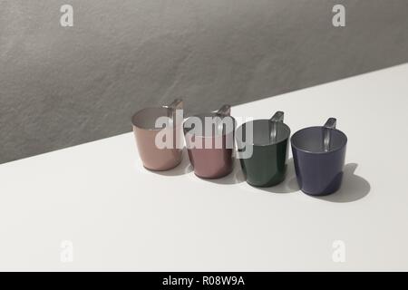 Quattro colorati tazze di caffè su un tavolo bianco (Pesaro, Italia, Europa) Foto Stock