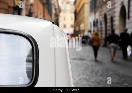 Un parcheggiato la Fiat 500 per le strade di Roma, alcune persone sullo sfondo. La Fiat Cinquecento 500 è un famoso simbolo italiano. Foto Stock