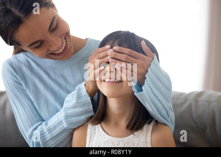 Madre preparare per la sorpresa di capretto coprire gli occhi con le mani Foto Stock