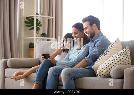 Famiglia trascorrono il tempo libero guardando cartoni animati sul telefono cellulare Foto Stock