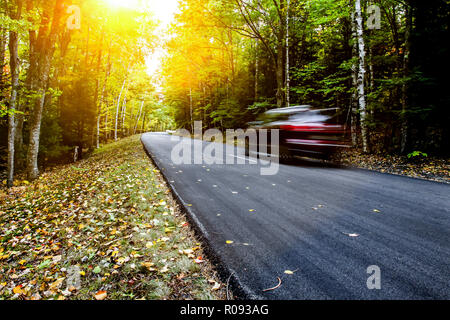 Car guida attraverso la strada d'autunno Foto Stock